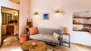 Un salon confortable avec un canapé, une table basse et une lampe.