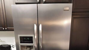 Ein Edelstahl-Kühlschrank mit digitaler Anzeige und Wasserspender.