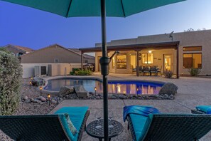 A backyard with a swimming pool, lounge chairs, and a patio area. - GOLF Oasis, MT Views, Htd POOL, Spa, Putt Green, Shuffleboard, 2 Bikes, Smart TVs (Gold Canyon)