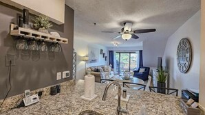 A modern kitchen with granite countertops, a built-in sink, and a ceiling fan. - Beautiful 2 BedroomVilla in Kingston Resort (North Myrtle Beach)