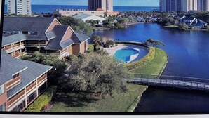 A residential area with a large body of water, a swimming pool, and several multi-story buildings in the background. - Beautiful 2 BedroomVilla in Kingston Resort (North Myrtle Beach)