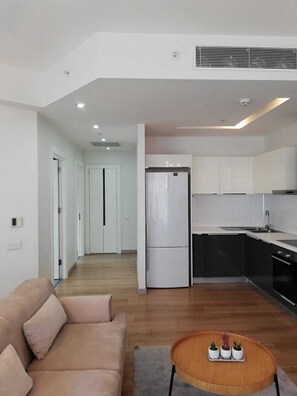 A modern apartment with a living room, kitchenette, and a hallway leading to another room. - Mall Of İstanbul Residence (Istanbul)