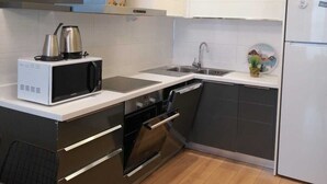 A modern kitchen with a built-in oven, microwave, and dishwasher. - Mall Of İstanbul Residence (Istanbul)