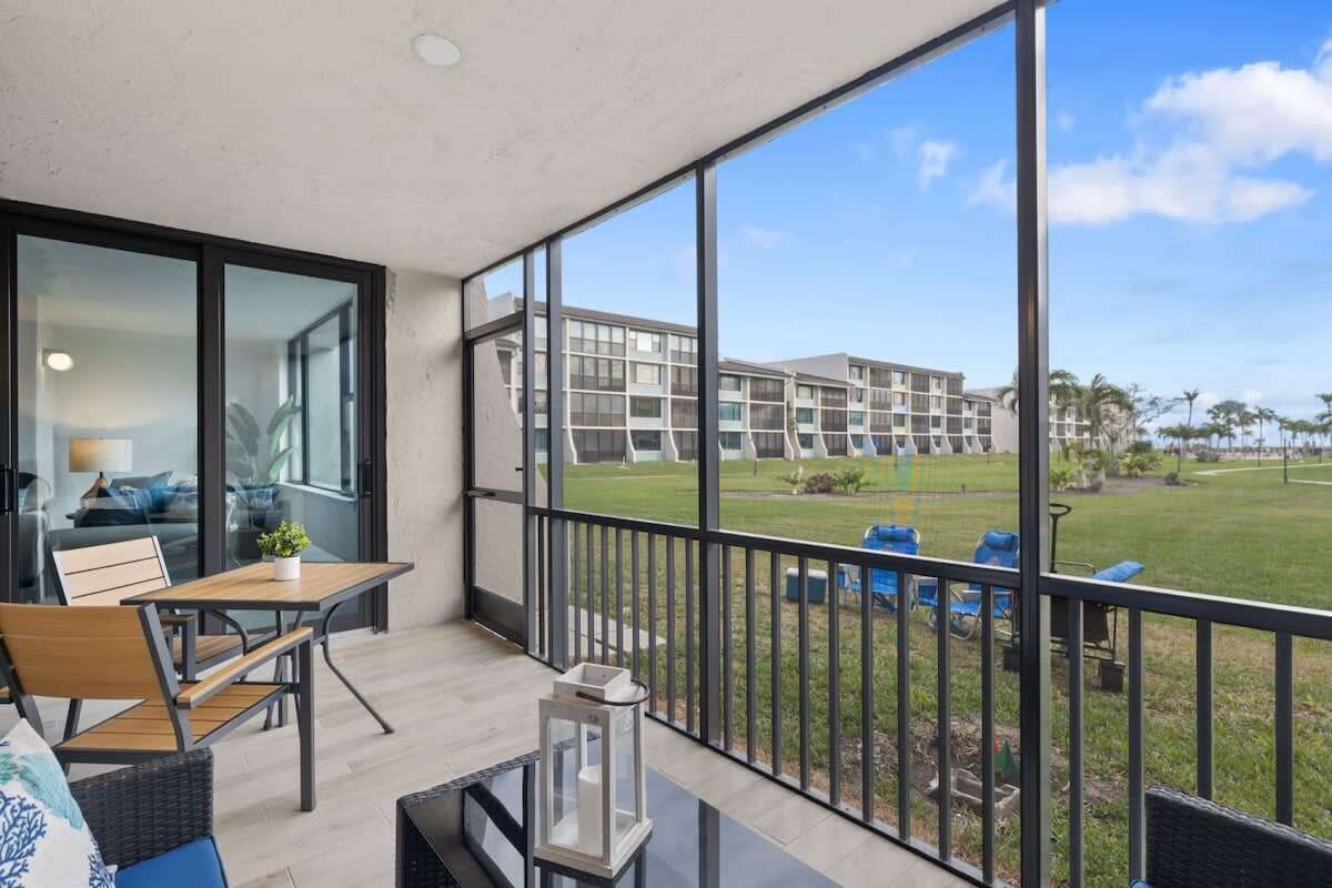 Un balcon donnant sur un immeuble et une zone verdoyante.