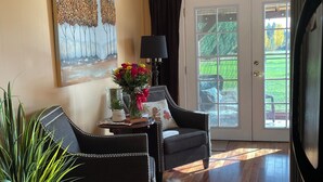 Ein Wohnzimmer mit Sofa, Sessel und einer Topfpflanze.