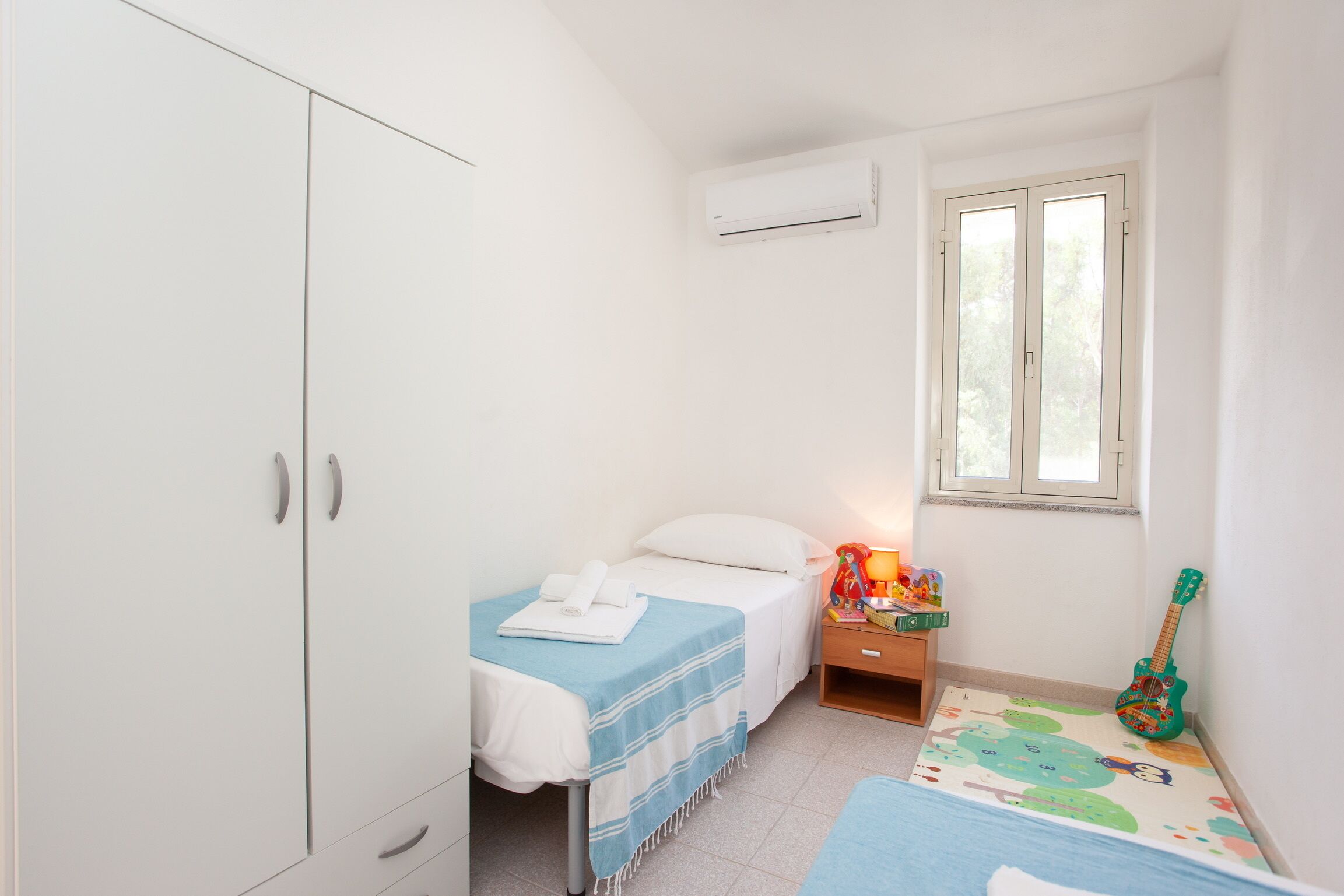 Bright single room with AC, natural light, and family-friendly touches