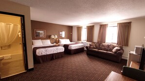 A hotel room with two beds, a sofa, a desk, and a television. - Star of The Lakes (Detroit Lakes)