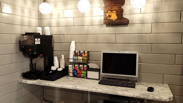 A coffee station with a coffee machine, cups, and a selection of coffee pods. - Star of The Lakes (Detroit Lakes)