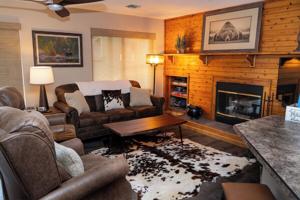 Ein gemütliches Wohnzimmer mit Ledersofas, einem Holztisch und einem Kamin.