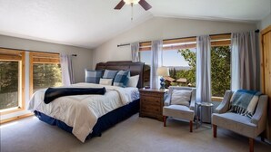 Ein Schlafzimmer mit einem Bett, einem Nachttisch, einem Sessel und einem Deckenventilator.