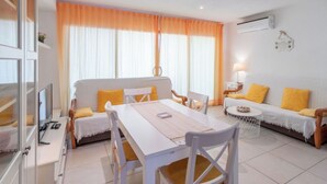 Une chambre d’hôtel moderne comprenant un coin repas, un ensemble de canapés et un téléviseur.