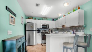 A kitchen with white cabinets, a stainless steel refrigerator, a microwave, and a sink. - 🌅Steps2Sound|Pool|Spacious 1BR|Sunset Harbor Villas 313🌅 (Navarre Beach)