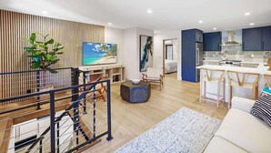 A modern apartment with a living area, kitchen, and balcony.