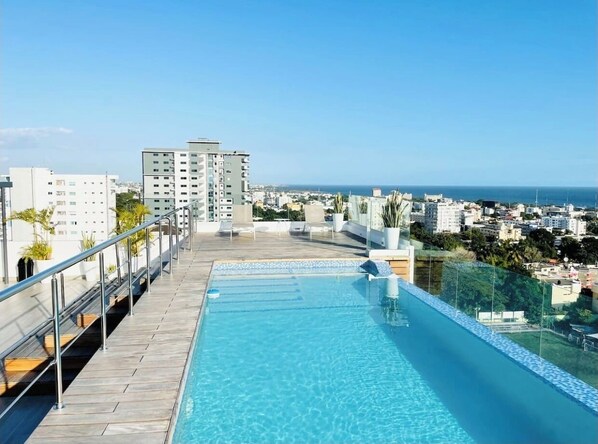 Relax by the rooftop pool overlooking the ocean and city views.