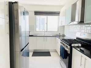 Enjoy cooking in this well-equipped kitchen with a gas stove, refrigerator, and ample cabinetry.