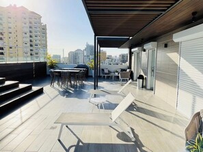 Relax on the outdoor terrace with a seating area, pergola, and city views.