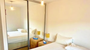 A hotel room with a large bed, a bedside table, a mirror, and a nightstand with lamps. - 3 bed (2 bath) whole home with free parking - 3 miles from Edinburgh airport (Edinburgh)