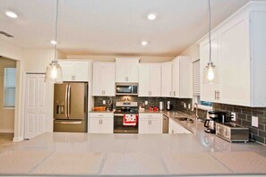 Enjoy cooking in this well-equipped kitchen with a large island, oven, and stainless steel appliances.