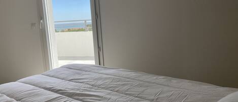 Una camera da letto con un letto, una finestra e vista sul mare.