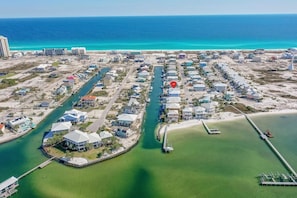 Vista aérea de una zona residencial costera con casas, un puerto deportivo y una playa.