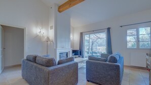 A spacious living room with grey sofas, a fireplace, and large windows. - 2-BEDROOM TOWNHOUSE WITH NICE VIEW (N°552) (La Motte)