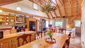 Una cocina amplia con armarios de madera, una mesa de comedor y una araña.