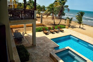 Un espace piscine offrant une vue sur la plage et l’océan.