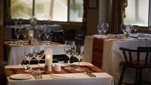 A restaurant table set with wine glasses, a candle, and cutlery. - La Montagne (Ballito)