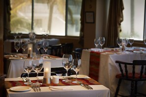 A restaurant table set with wine glasses, a candle, and cutlery. - La Montagne (Ballito)