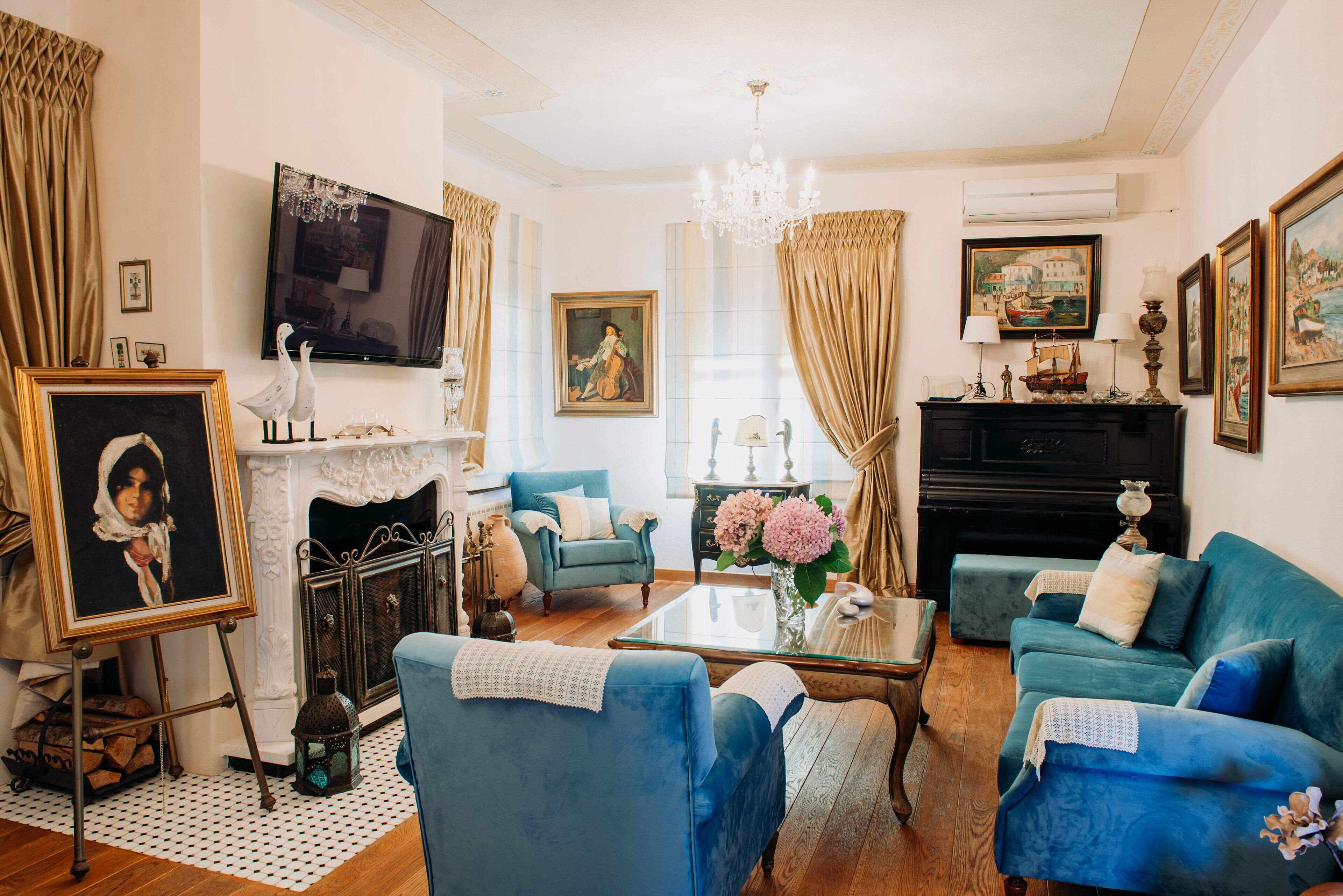 A living room with a fireplace, blue sofas, a TV, and various decorative items.