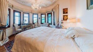 Une chambre spacieuse avec un grand lit, un bureau et une chaise.