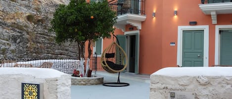 Un hotel con una escalera de piedra que lleva a un balcón con una hamaca colgante.