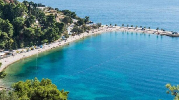 A coastal area with a curved bay, a beach, and a small peninsula with trees and buildings. - Apartment Alba - Three Bedroom Apartment with Loggia (Split)