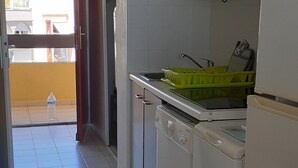 A kitchen with white cabinets, a dishwasher, and a refrigerator. - LE CAP D'AGDE - near sea - Appt tt confort - residence with swimming pool - Pk private (Agde)