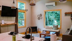 Eine moderne Küche mit Einbauherd, ein Essbereich mit Tisch und Stühlen und ein gemütliches Wohnzimmer mit Sofa und Kamin.