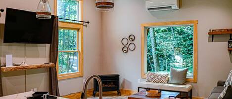 A modern kitchen with a built-in stove, a dining area with a table and chairs, and a cozy living room with a sofa and a fireplace.