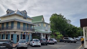 Un edificio de dos pisos con un balcón y techo verde.