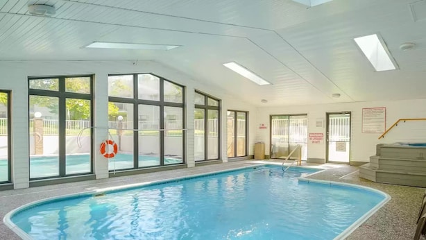 An indoor swimming pool with clear glass walls, a lifebuoy, and a "No Lifeguard on Duty" sign. - 3 Min to Strip! Large Condo, Arcade Game, Pools, Hot tub, Sauna, Golf & Shows! (Branson)