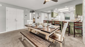 A dining area with a wooden table set for four, benches, and a ceiling fan. - 3 Min to Strip! Large Condo, Arcade Game, Pools, Hot tub, Sauna, Golf & Shows! (Branson)