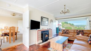 A living room with a fireplace, a sofa, a coffee table, and a TV. - Beach Haven (Wadebridge)