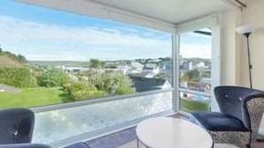 A balcony with a view of a town, a table, and two chairs. - Beach Haven (Wadebridge)