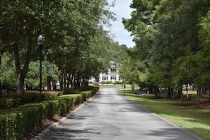 Stroll along the well-maintained pathway to the stately building, featuring a central entrance and symmetrical windows.