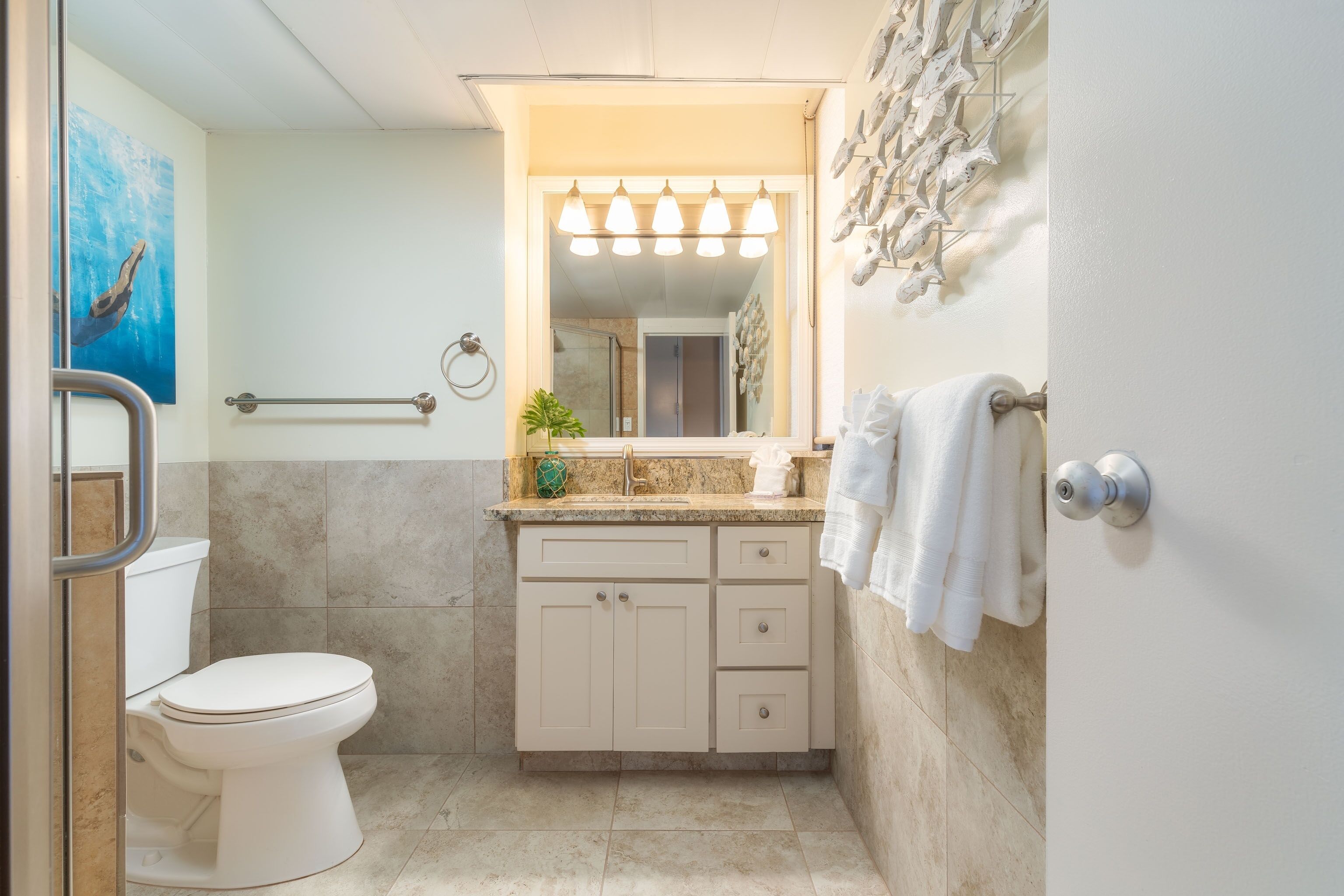 Une salle de bain moderne équipée de toilettes, d’un lavabo et d’un miroir.