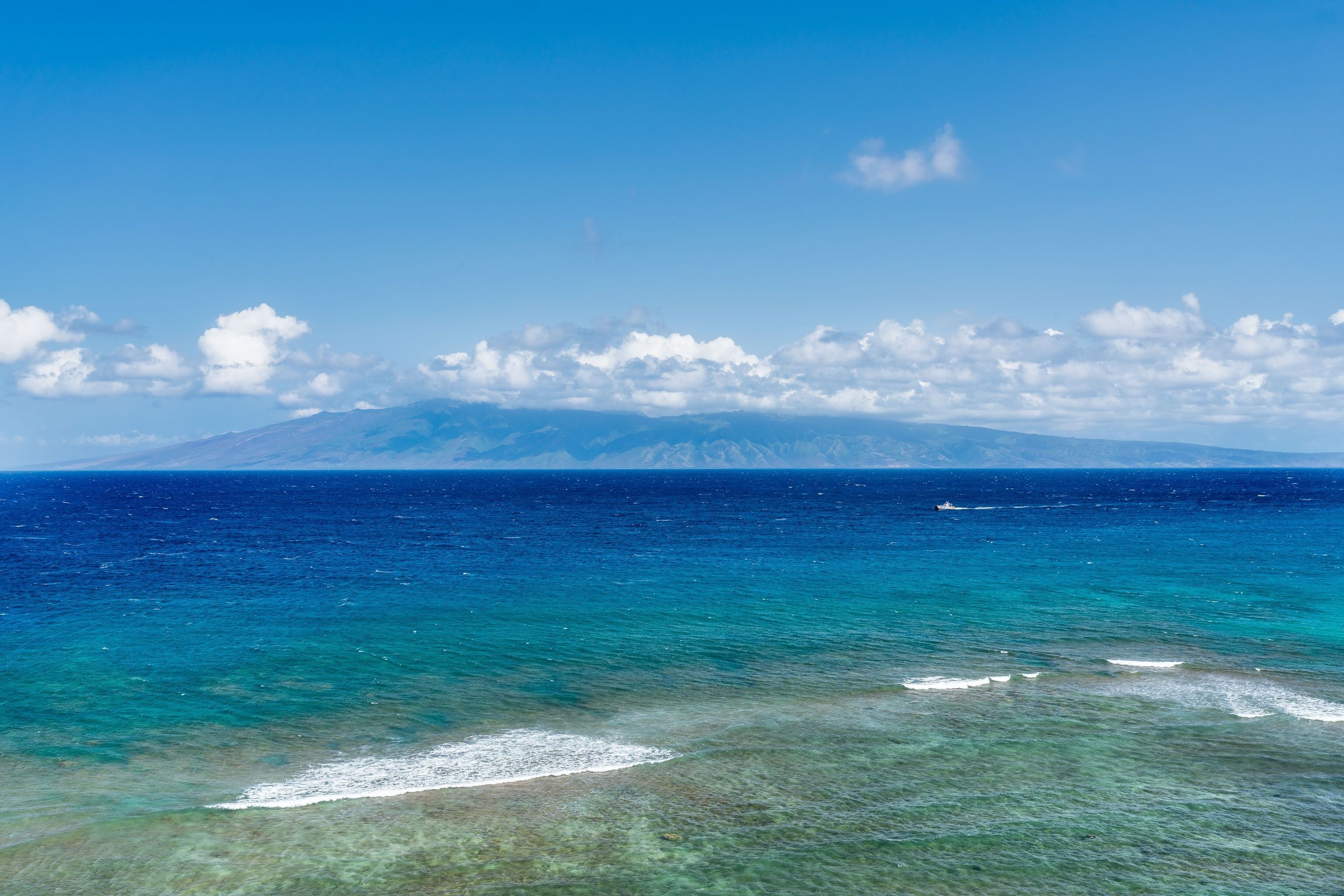 A clear view of a coastal landscape with a mountain in the background.