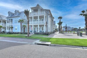 A large, multi-story building with a prominent balcony and a flag. - The Reel Deal 222 GR (Port Aransas)