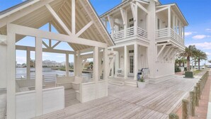 A coastal building with a wooden deck, multiple balconies, and a view of the water. - Edgewater Escape 541 SOU (Port Aransas)
