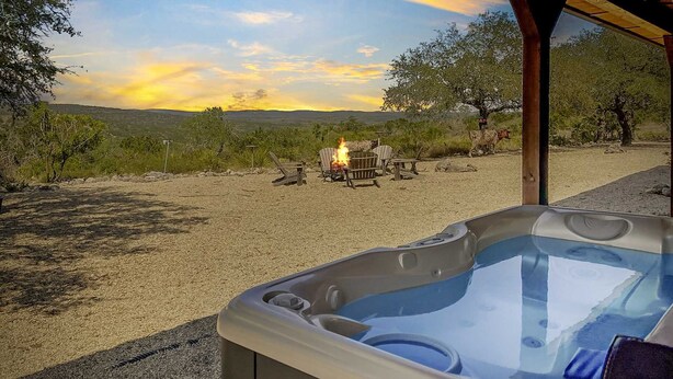 A hot tub with a clear view of a sunset and a campfire in the background. - Ranchito in Hondo Texas (Hondo)