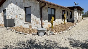A stone building with a sloped roof, a chimney, and a satellite dish. - Ranchito in Hondo Texas (Hondo)