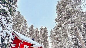 A red cabin surrounded by snow-covered trees. - Pajalan piilopirtti by Interhome (Kuusamo)