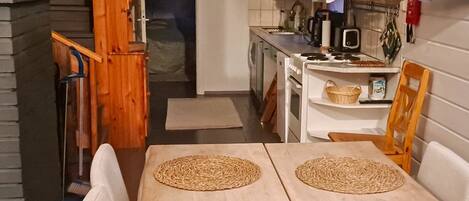 Een koelkast, een magnetron, een vaatwasser, kookgerei, borden en bestek